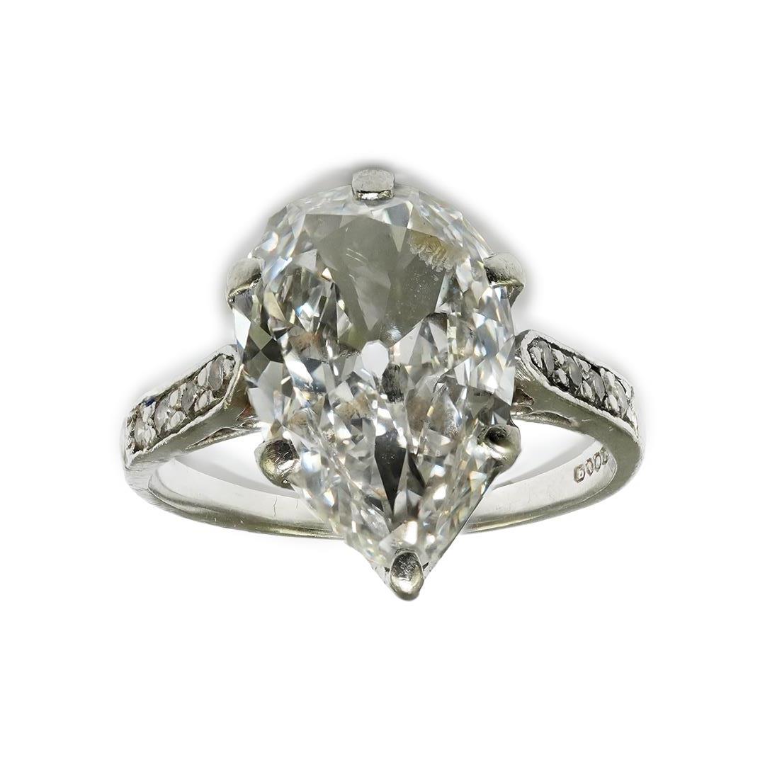 A platinum and pear cut single stone diamond set ring, with diamond set shoulders